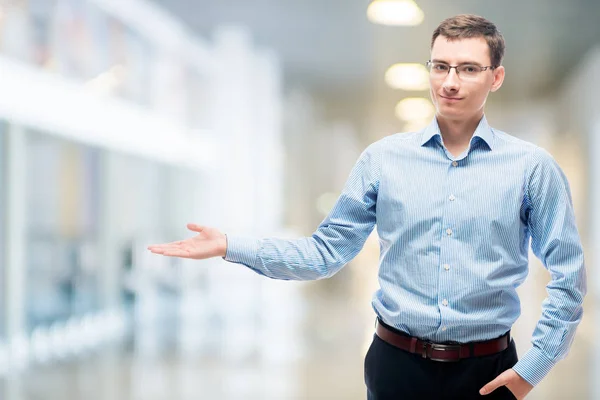 Businessman presenting space to the left in office — Stock Photo, Image