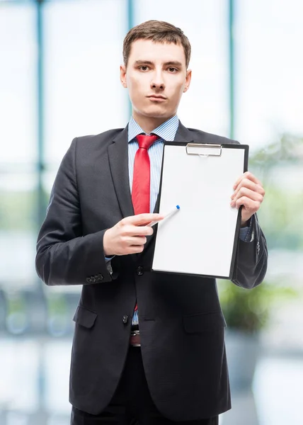 Молодой бизнесмен с папкой, в которой чистый лист бумаги — стоковое фото