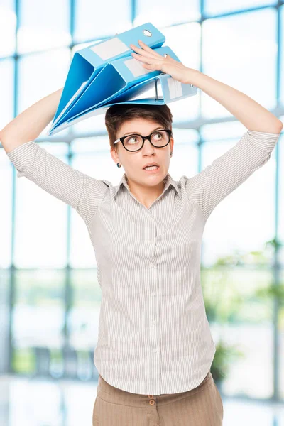Сумасшедшая женщина с папками на голове в офисе работника — стоковое фото