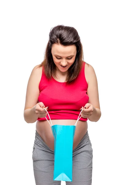 Surpresa mulher grávida feliz espreitando em um pacote com bolsa — Fotografia de Stock