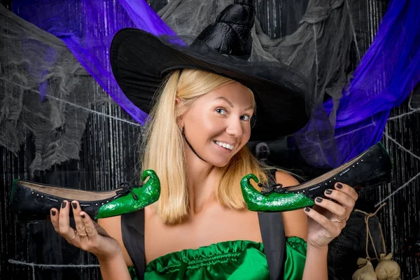 Bella strega in un cappello con scarpe di Halloween verde — Foto Stock