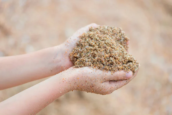 children\'s hands with wet sand close-up