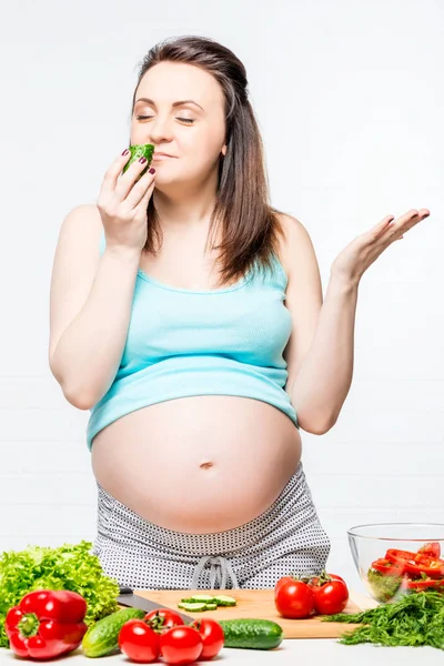 Glückliche schwangere Frau mit Gemüse auf dem Tisch bereitet eine sa — Stockfoto