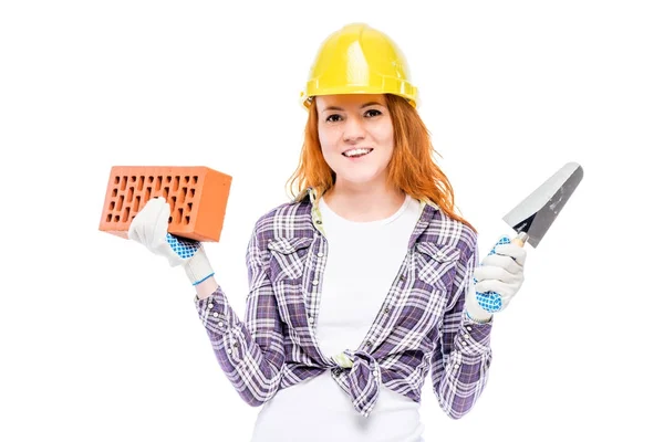 Mujer constructora con un ladrillo y una paleta sobre un fondo blanco —  Fotos de Stock