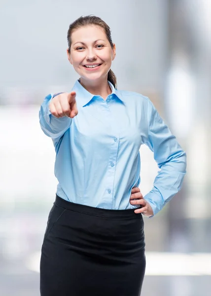 Young brunette woman in a blue shirt chooses you! — Stock Photo, Image