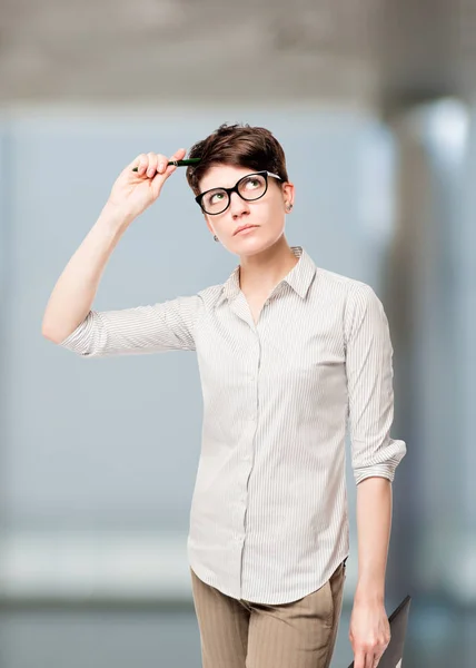 Chica con una camisa a rayas con una vista reflexiva en la oficina — Foto de Stock