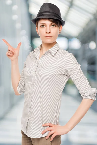 Woman in a black hat shows his finger to the side isolated in th — Stock Photo, Image
