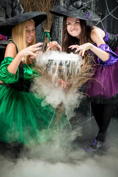 Dvě zlé čarodějnice uvařit lektvar v hrnci, na Halloween — Stock fotografie