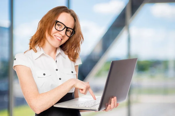 Happy businesswoman presses a button on the laptop in the office — Stock Photo, Image