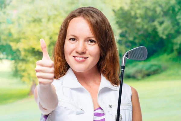 Golfista sorridente mostrando polegares para cima em um fundo de campos de golfe — Fotografia de Stock