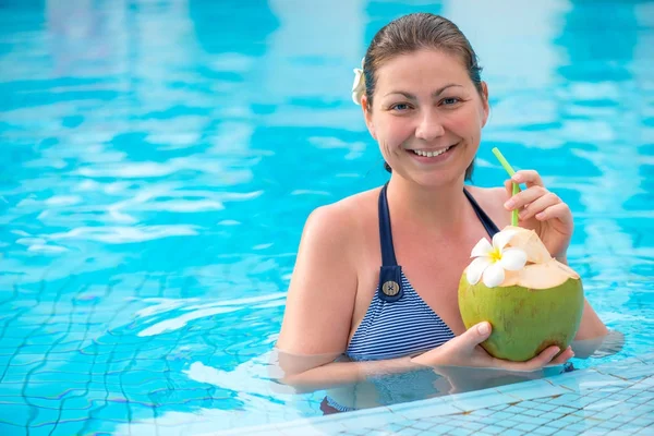 Fille avec une noix de coco dans la piscine reposant — Photo