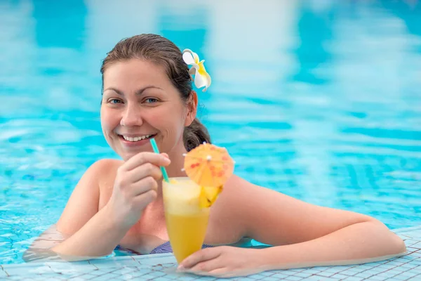 Женщина 30 лет в бассейне, наслаждаясь отдыхом и коктейлем — стоковое фото