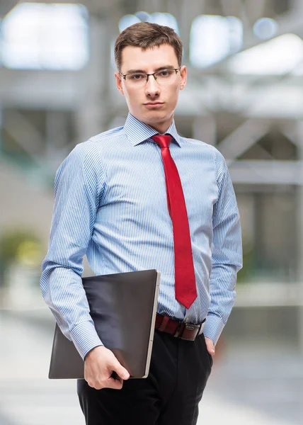 Experienced young accountant in blue shirt holds a laptop, portr — Stock Photo, Image