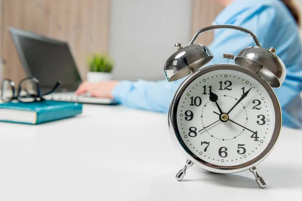 Empresária que trabalha no escritório, em foco, um despertador em — Fotografia de Stock