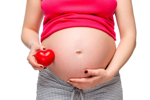 Close-up dari perut seorang wanita hamil dengan bentuk hati merah — Stok Foto