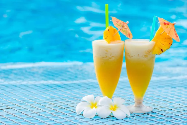 Pineapple cocktail beautifully decorated with umbrellas and flow — Stock Photo, Image