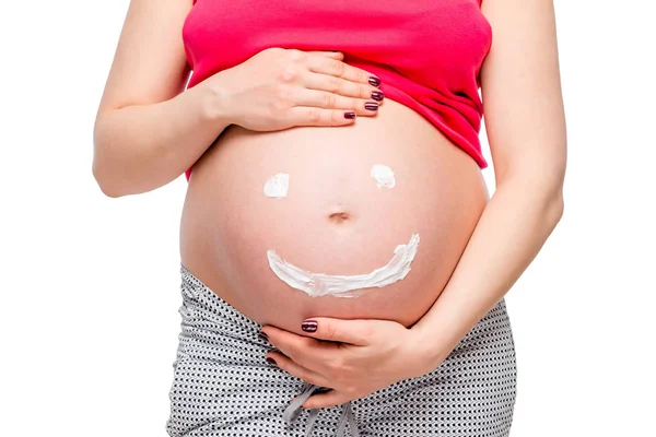 Mujer embarazada toca el estómago en el que se pinta una sonrisa Fotos de stock libres de derechos