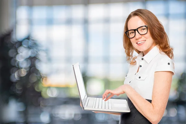 Beautiful slim secretary with a laptop in the office — Stock Photo, Image