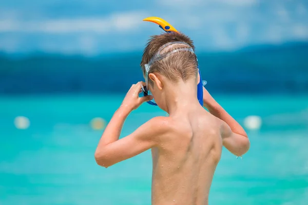 Ребенок носит маску для подводного плавания на берегу моря в тропиках — стоковое фото