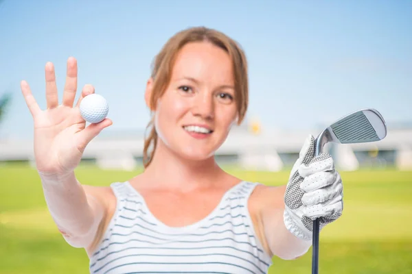 Menina sorridente mostra uma câmera na bola e um taco de golfe em um whi — Fotografia de Stock