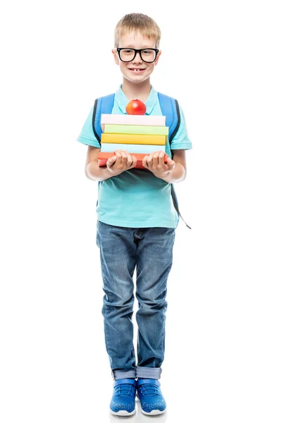 Slimme scholier met een bril met een stapel boeken en een appel — Stockfoto