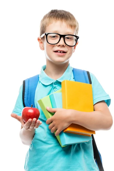 Écolier avec des livres montrant une pomme rouge pour le déjeuner sur une ba blanche — Photo