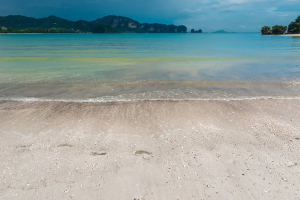 Egy elhagyatott homokos strand és egy gyönyörű tengerre néző előtt az esőben, mint — Stock Fotó