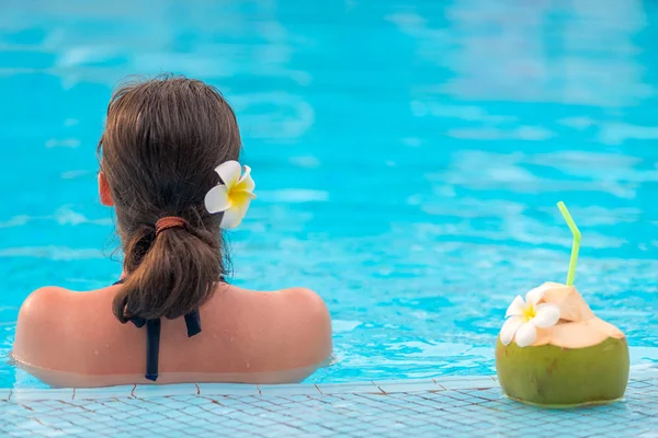 Mujer vista desde atrás en la piscina y coco verde con paja —  Fotos de Stock