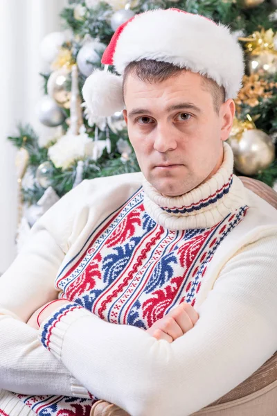 Portrét muže, který seděl v křesle u vánoční jedle — Stock fotografie