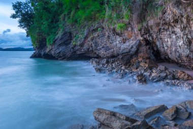 rock yakınındaki gün batımında uzun pozlama üzerinde geçerli deniz suyu