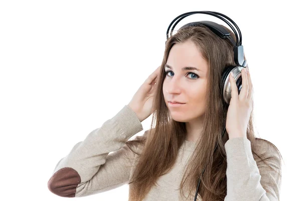 Όμορφη νεαρή κοπέλα με τα ακουστικά που παρουσιάζουν σε λευκό φόντο — Φωτογραφία Αρχείου