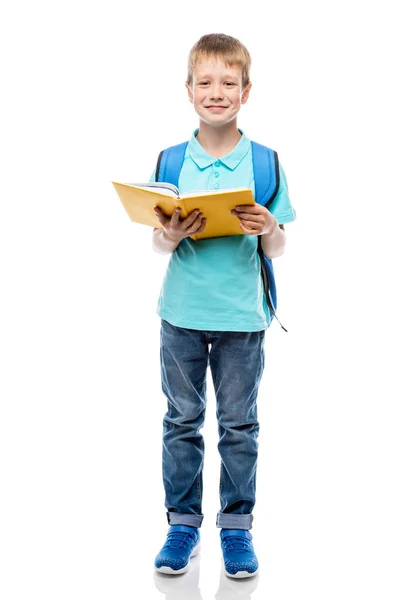 Αγόρι με σακίδιο και βιβλίο θέτοντας σε άσπρο φόντο στο studio — Φωτογραφία Αρχείου
