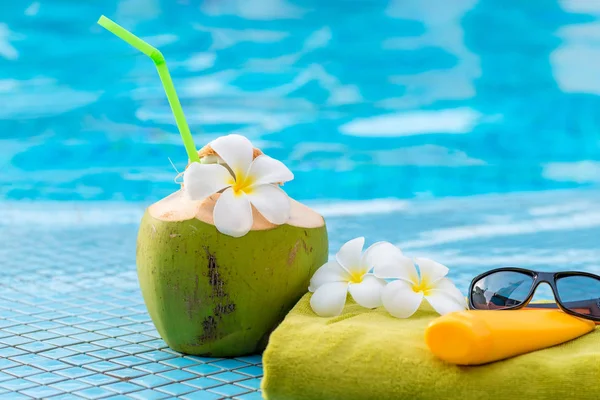 Coconut milk and beach accessories close-up on the edge of the p — Stock Photo, Image
