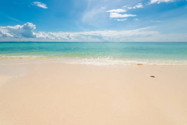 Areia fina na praia, mar azul calmo e nuvens bonitas em um — Fotografia de Stock