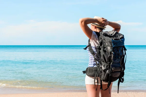 Уставший турист с рюкзаком у моря наслаждаясь видом — стоковое фото