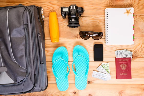 Objekte reisen auf einem Holzboden in der Nähe eines Koffers — Stockfoto