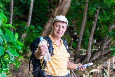 bir şişe su veren genç turist adam