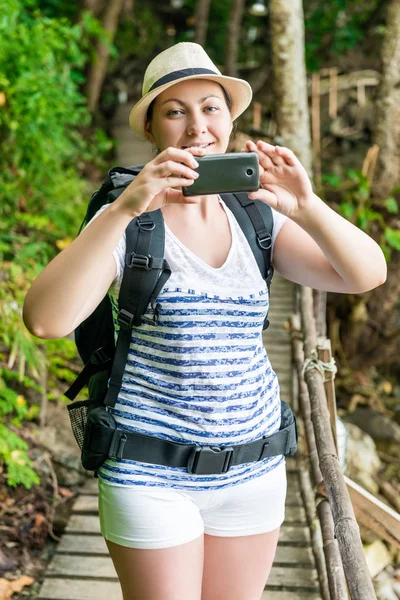Portrait vertical d'un touriste avec un téléphone et un sac à dos sur un — Photo