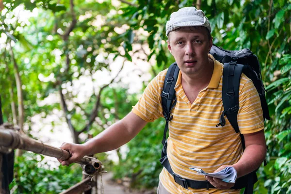 Turista masculino com uma mochila na selva descansando — Fotografia de Stock