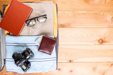 Giysi ve aksesuarları ahşap kurullarında erkek bavulla spa