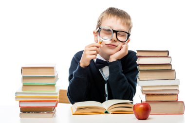 Büyüteç masasında görmek bir yığın kitap üzerinde beyaz bir çocukla 