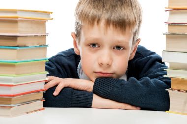 yorgun okul çocuğu yakın bir yığın kitap arasında portresi