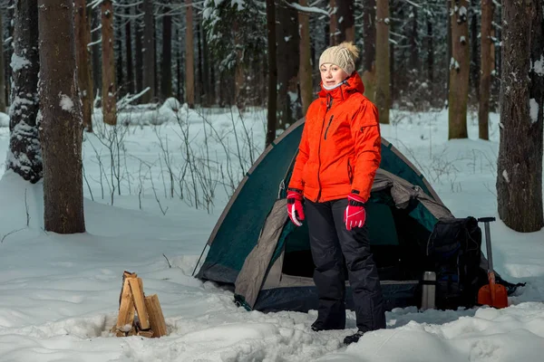 Mulher perto de uma tenda em um local de acampamento em uma floresta de inverno no mo — Fotografia de Stock