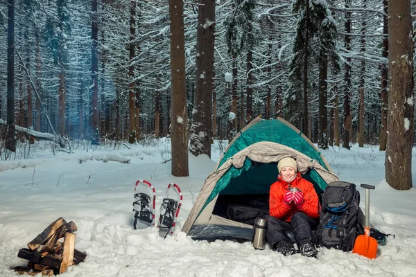 Žena s horkým čajem v stanu v zimním lese — Stock fotografie