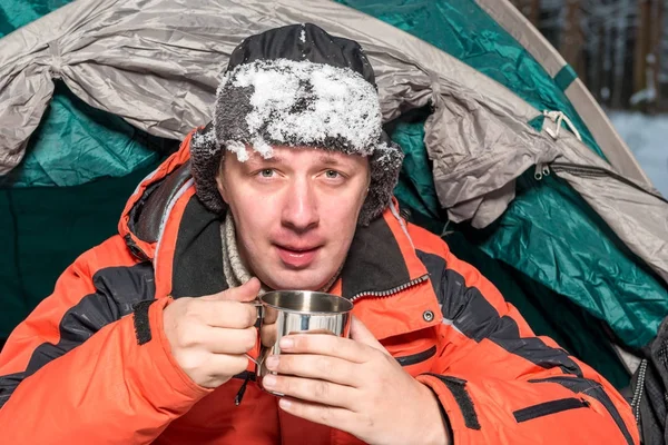 Portret van een bevroren man met sneeuw op een hoed met hete thee in een certificeringsinstantie — Stockfoto