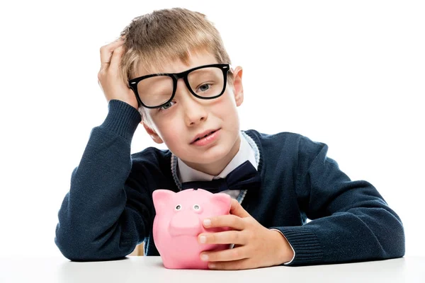 Retrato de un niño cansado en gafas con una alcancía rosa en una w — Foto de Stock