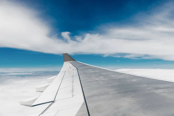 Ala in acciaio dell'aeroplano primo piano e nuvole leggere ad alta altitudine — Foto Stock
