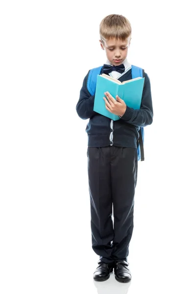 Scolaro con libro di testo e zaino su uno sfondo bianco in fu — Foto Stock