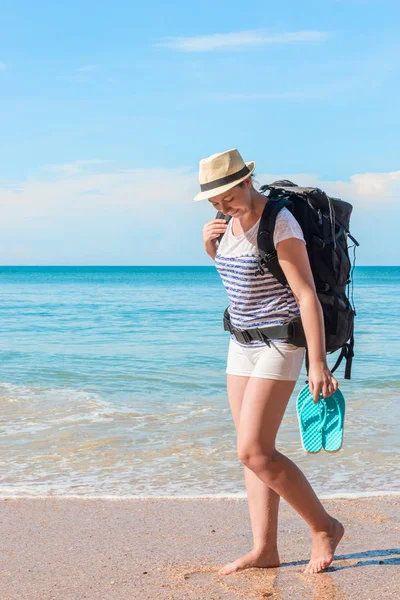 Portrait of a tourist girl with a backpack on the sandy beach of — Stock Photo, Image