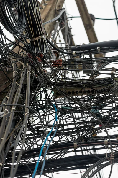 Close-up de fios pendurados aleatoriamente em postes elétricos na Tailândia — Fotografia de Stock